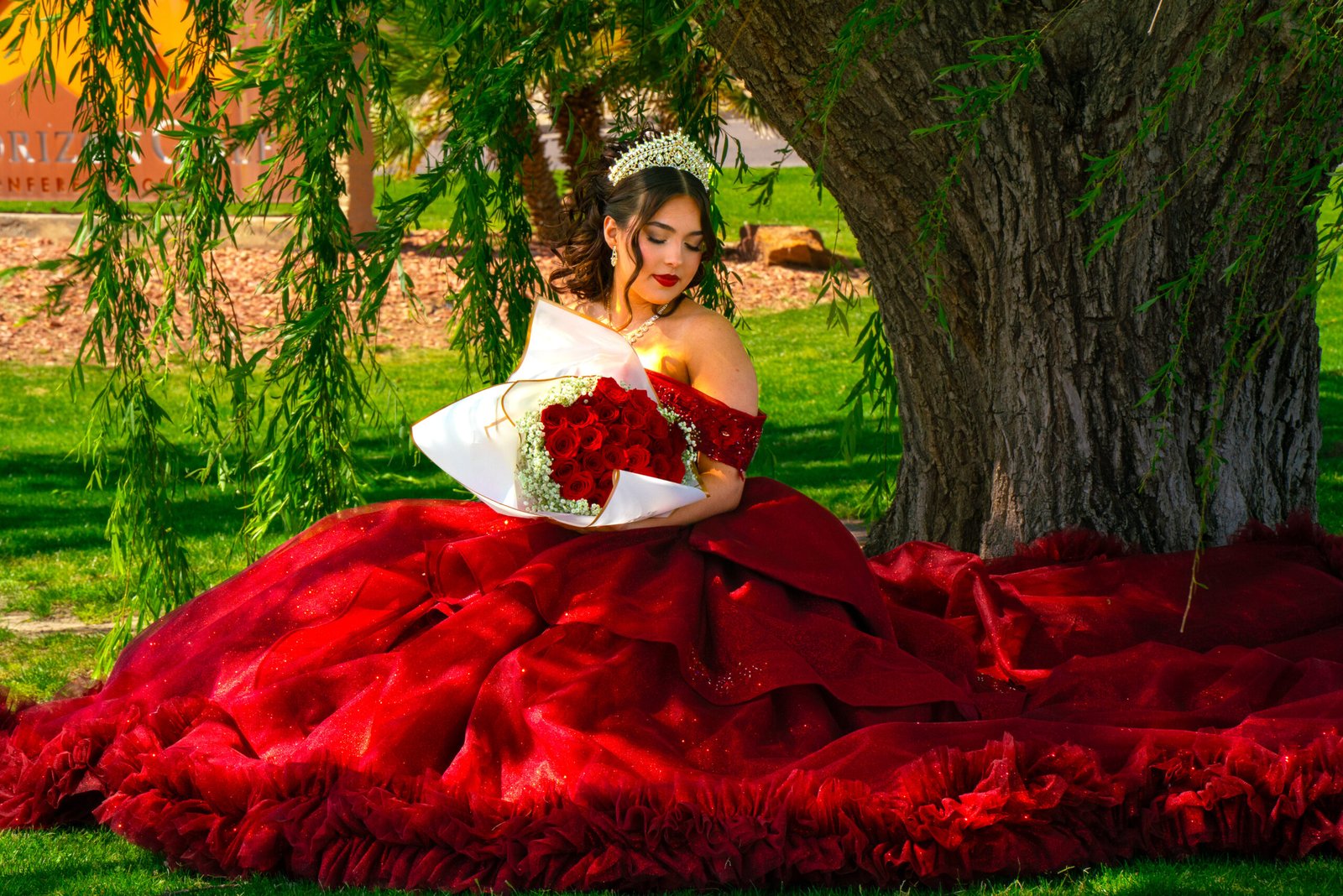 Young woman in a red dress posing outdoors.